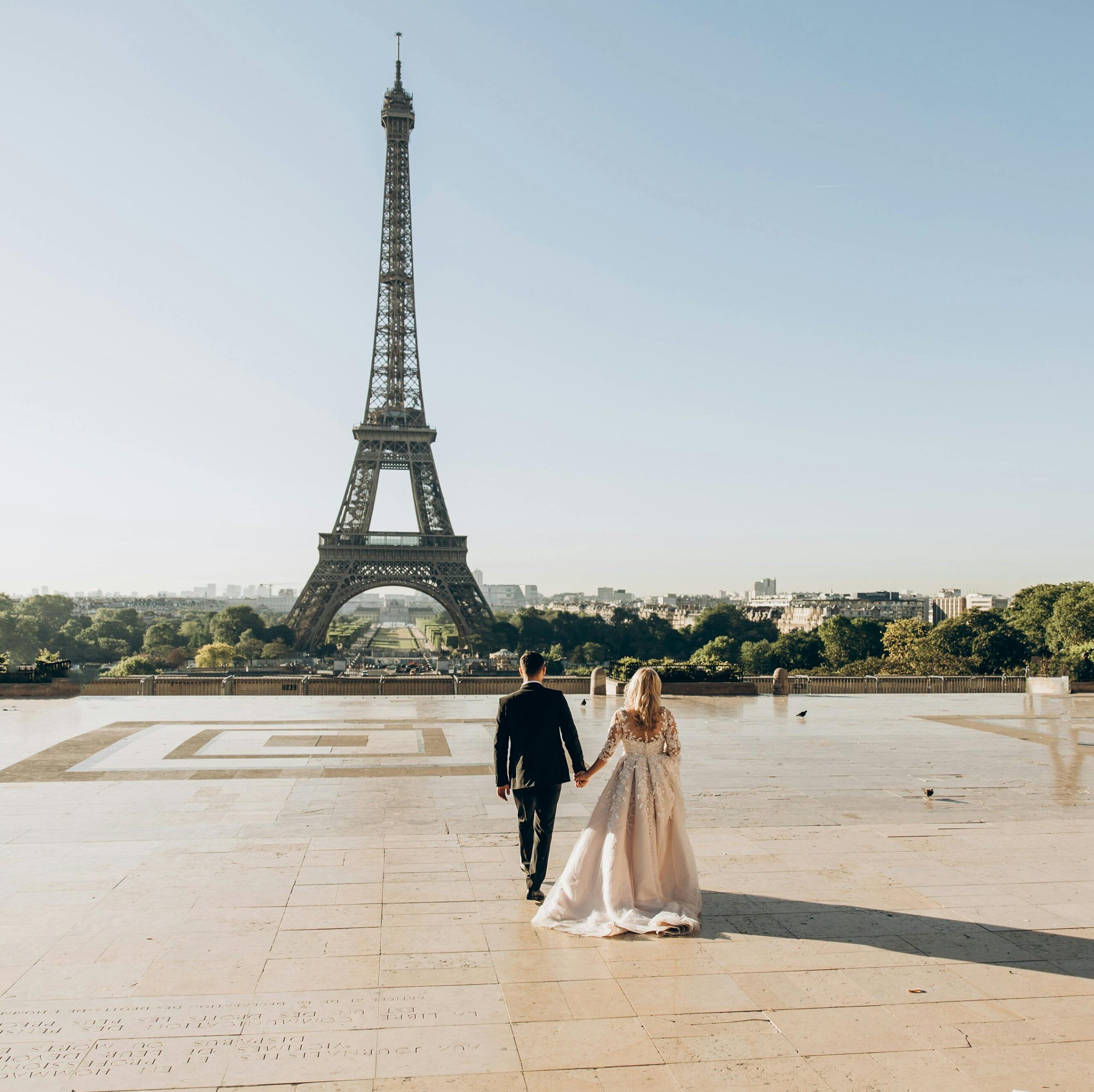 A bride and groom sharing a romantic moment in front of the iconic Eiffel Tower in Paris.